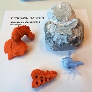 Figure 3: a teen program participant examines different modes of art making both old and new using 3D-printing and carving in alabaster.