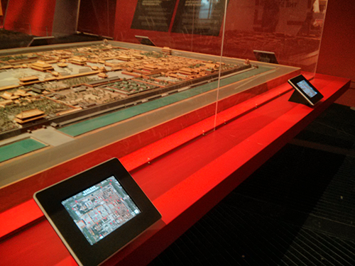 An iPad next to a scale model of a city